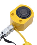 Close-up of yellow hydraulic cylinder jack head with black circular top and metal hose fitting.
