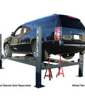 Top Shelf Four Post Vehicle Parking Lift With Massive Eight Thousand Pound Load Capacity And Heavy Duty Diamond Plate Runways For Your Weekend Wrencher Shop, featuring a raised black SUV on a sturdy lift.