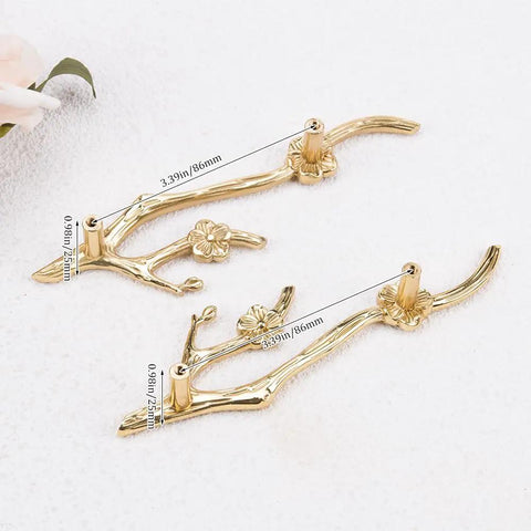 Two Slick Twig Drawer Pulls In Polished Brass Plum Blossom Branch Handle For Cabinets And Dressers on white surface