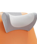 Gray and white ergonomic neck pillow for recliners and couches, memory foam headrest cushion hanging over back of orange chair.