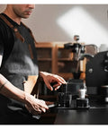 Man using Top Shelf Espresso Needle Wdt Tool For 58mm Portafilter Black coffee ground stirrer on a counter.