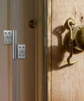 A Detachable Flag Hinges Built Tough Heavy Duty Stainless Steel Interior Door Hinges 5 Inch By 2.5mm Thick Weld On next to a wooden door.