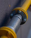 Close-up of a yellow-flanged bolt assembly with a threaded steel rod.
