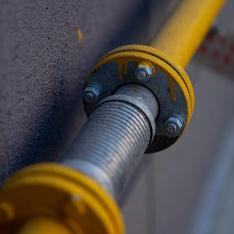 Close-up of a yellow-flanged bolt assembly with a threaded steel rod.