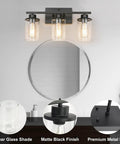 Slick Black 3 Light Vanity Light Fixtures Over Mirror With Clear Glass Shades in bathroom setting, round mirror reflection.
