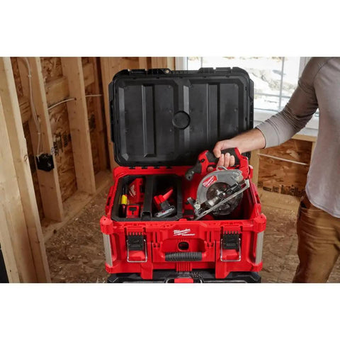 Person holding M12 Fuel 5-3/8 Inch Circular Saw Cordless With Brushless Powerstate Motor And REDLINK Plus Intelligence in a toolbox
