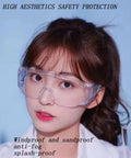 Woman wearing dustproof and splashproof louvered safety goggles with wraparound protection against a blue background.