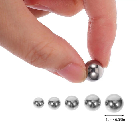 580-Piece Stainless Steel Bearing Balls Kit 1.0mm Through 10.0mm Portable Precision Balls For Mechanical And Industrial Use, Wear-Resistant, Easy-Storage Assortment Built For DIYers And Pros In The Shop. stainless steel bearing balls held between fingers, with 1cm size guide