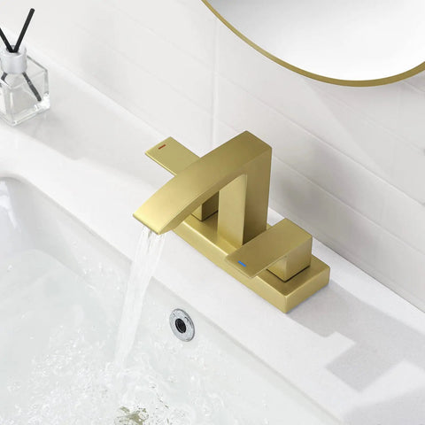 Gold modern faucet with waterfall spout on white sink