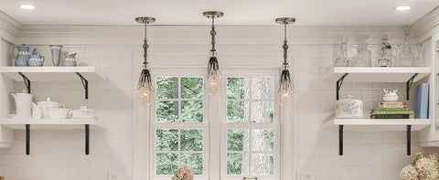 Kitchen with black L-shaped brackets supporting white shelves, displaying dishes and decor items, under pendant lights.