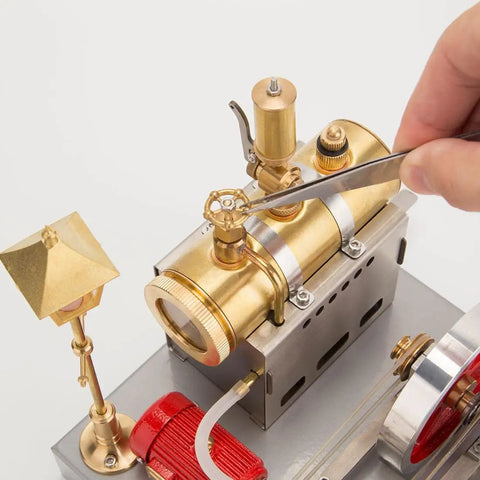 Close-up of Steam Engine Kit With Boiler, Generator And Street Lamp showing brass boiler and adjustment tool in use.