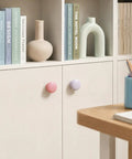 Six Pack Round Wooden Cabinet Knobs In Crisp White With Trimmable Screws For Zero Fuss Dresser And Closet Swaps With Pink And Purple Accents.