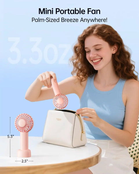 Mini Portable USB Rechargeable Handheld Fan, 3 Speeds, Cute Pink Travel Companion demonstrated by a woman with a purse