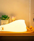 Flat Lying Duck Night Light For Kids Soft Silicone Nursery Lamp glowing on wooden shelf with touch control and Type C rechargeable battery