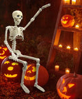 36 Inch Full Body Skeleton Prop With Movable Joints Realistic Plastic Bones in outdoor Halloween scene with jack-o'-lanterns