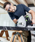 User operating a Heavy Duty Plunge Cut Saw With Precision Anti Splinter Guard And Aluminum Guide Rail for cutting on a marble work surface.