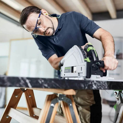 User operating a Heavy Duty Plunge Cut Saw With Precision Anti Splinter Guard And Aluminum Guide Rail for cutting on a marble work surface.