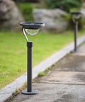 50 Lumen Solar Path Lights 42X Brighter Than Standard Garden Lighting Matte Black 4 Pack installed along a garden path
