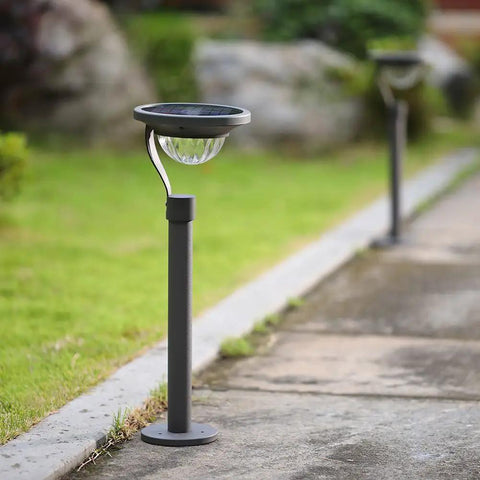 50 Lumen Solar Path Lights 42X Brighter Than Standard Garden Lighting Matte Black 4 Pack installed along a garden path