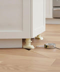 Durable PP Plastic Adjustable Cabinet Leveling Foot 4 Inch Furniture Leg under kitchen cabinet on wooden floor with measuring tape
