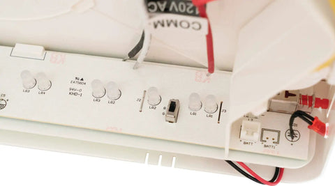 Close-up of the interior wiring in a 2 In 1 LED Exit Sign And Emergency Light Combo For Busy Biz Spaces with white housing and components.
