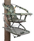 Titan Sd Climbing Treestand With Roomier Design Bigger Top Seat Frame And Longer Foot Platform For Large Frame Hunters Supports Up To 350 Pounds Heavy Duty Premium Tree Stand With Five Year Limited Warranty, featuring camo design and attached to tree.