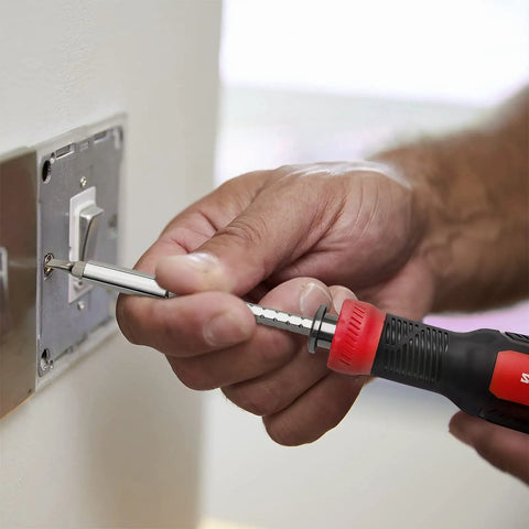 Person using Multi Screwdriver 13 In 1 Set With 1/4 Nut Driver And 12 Bits Including Torx Security for quick DIY fix on light switch
