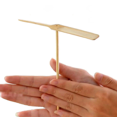 Close-up of hands holding a wooden dragonfly propeller from the Dragonfly Propeller Toys Set For Outdoor Fun, 10 Pack Wooden Flying Dragonflies For Boys And Girls, Lightweight Hand Rub Action, Totally Kid-Friendly, Boosts Motor Skills And Hand-Eye Coordination, Confidence Builder, Portable 14.5 X 16 Cm