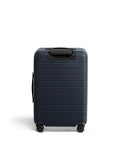 Bigger Carry On Luggage From Away, navy blue suitcase with spinner wheels, TSA lock, durable polycarbonate shell, ideal for travel.