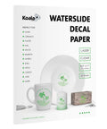 Package of Clear Waterslide Decal Paper for Laser Printers, 8.5x11, 25 Sheets, shown with mugs, candles, and wood examples.