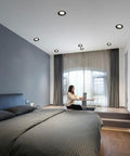 Round Led Recessed Spotlights in a bedroom with slick brushed brass and matte black trim, illuminating a workspace.