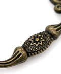 Close-up of vintage antique brass bail pull handle detail for wooden drawers, featuring retro diamond base and press forged detail.