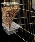 Dope Game Changer No Mess Bird Feeder For Cage With Auto Seed Guard, clear feeder with seeds attached to cage.
