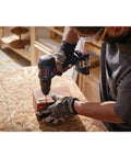 Person using 18V EC Brushless Hammer Drill Driver With Half Inch Capacity on wooden block in workshop