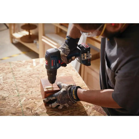 Person using GSB18V-490B12 18V EC Brushless Half Inch Hammer Drill And Driver Kit with 2 Ah Battery on wood project