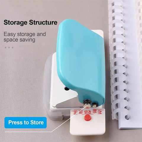 6 Hole Punch Handheld Metal Craft Tool For Binding Notebooks And Scrapbooks, resting next to spiral notebook, easy portable design