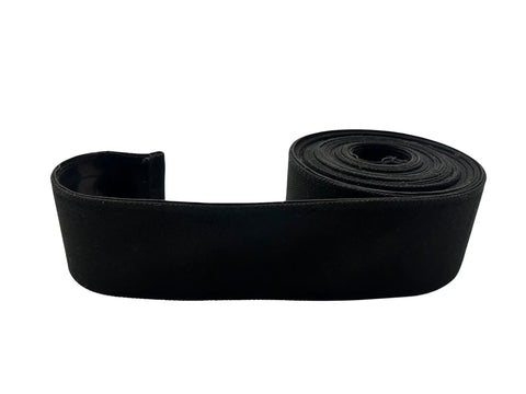 Adjustable Under Couch Gap Shield blocking toys dust and remotes, 10-foot flexible black roll for sofas and beds.