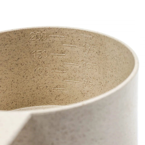 Wheat Straw Measuring Cups And Spoons Set Ten Piece For Cooking And Baking with engraved measurement markings inside a cup
