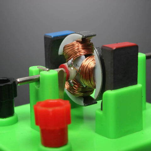 Close-up of copper wound DC motor model in Hands On Circuit And Motor Lab Kit For Students DIY STEM projects, mounted on green base.