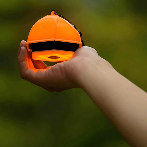Hand holding 2-In-1 Camping Light And Tent Lantern For Outdoor Adventures, waterproof portable lantern in bright orange