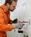 Worker using a power drill on a wall while wearing gloves, demonstrating installation for Heavy Duty Stainless Steel Blind Rivets 100 Piece Set 11/64 X 13/64 Inch Dome Head Fasteners Rock Solid Grip For Sheet Metal Projects And Hardware Builds Dead Easy To Install With Zero Sweat On DIY Jobs Or Pro Repairs.