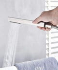 Floor Mounted Tub Filler Faucet With Handheld Sprayer And Waterfall Spout, brushed nickel sprayer in use over tub.