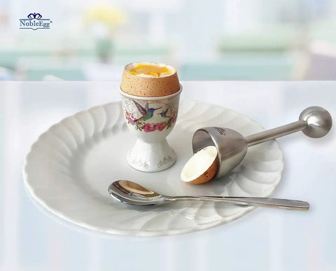 Egg Topper Opener Tool With Vibration Cut For Soft Boiled Eggs next to a porcelain egg cup on a white plate.