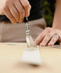 Hella Strong Contact Cement For Wood And Metal Projects Heavy Duty Adhesive For Laminates And Veneers Interior Exterior Bonding Solution That Bonds Like Crazy In A Convenient Three Ounce Tub being applied with a brush.