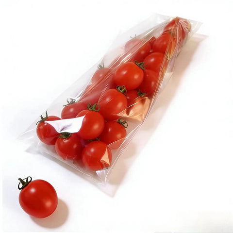 Compact Horizontal Flow Wrapper Shrink Wrap Machine 50 To 80 Pieces Per Minute with sealed cherry tomatoes in clear film bag.