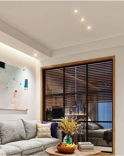 Silver Adjustable LED Recessed Spotlight illuminating a modern living room with sofa, decor, and window.