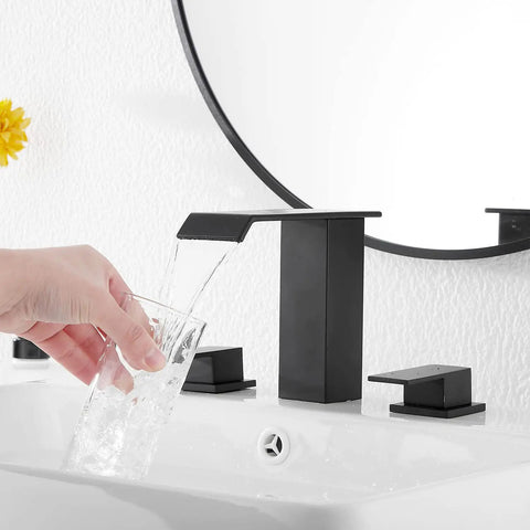 Pouring water into a glass from a Matte Black Waterfall Bathroom Faucet, Widespread 3 Hole 2 Handle Modern Sink Faucet With Pop Up Drain