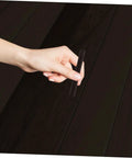 Hand holding 2 Pack Wood Filler Sticks for Furniture Repair Scratch Remover Pens Quick Fix Paint Markers against dark wood surface.
