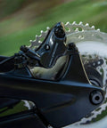 Close-up of Deore M6120 Hydraulic Disc Brake Front Post Mount Black Resin Pads Included Caliper on MTB wheel.