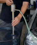 Hand Operated Manual Fluid Transfer Pump Stainless Steel Portable Siphon for Gas, Oil And Water in use with a barrel.